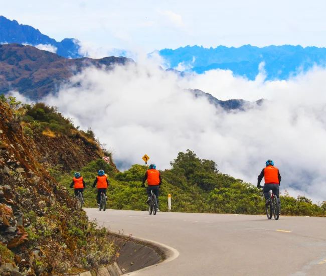 Downhill Biking on the Inca Jungle Adventure Tour | Conde Travel Adventures Adventure cyclist descending a winding road in the Andes on the Inca Jungle tour to Machu Picchu | Conde Travel Adventures