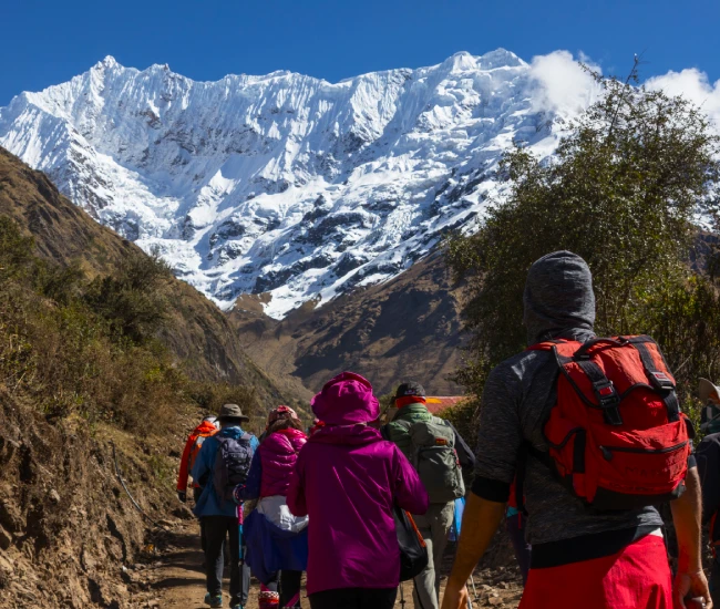 Travelers hiking beneath Salkantay Mountain on their journey to Machu Picchu Travelers hiking beneath Salkantay Mountain on their journey to Machu Picchu